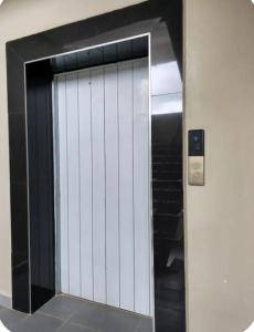 an elevator door in a building with a mirror at Royalty homes in Kiambu