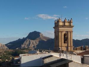 a building with a bell tower with mountains in the background at Can Perles casa rural in Tárbena