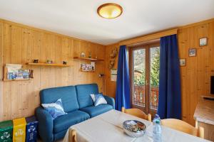 a living room with a blue couch and a table at Appartamenti Fabrizio in Livigno