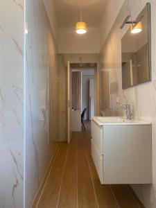 a bathroom with a white sink and a mirror at Partenopeo Rooms & Suite in Nola +17 photos