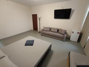 a living room with a couch and a flat screen tv at Отель Гетьман in Broska +19 photos