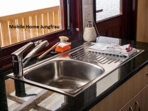 a stainless steel sink in a kitchen with a stove at Camping Jungfrau in Lauterbrunnen