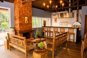 a living room with wooden benches and a bar at Fazenda Castanheira in Monte Verde
