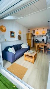 a living room with a blue couch and a table at Kust 3 in Egmond aan Zee