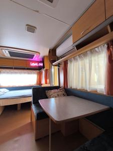 a room with a couch and a table in a train at Large camper in the olive grove in Banjole +80 photos