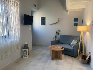 a living room with a blue couch and a table at Fedon in Halki