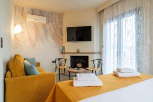 a bedroom with a bed and a living room with a fireplace at L anima II in Skiathos