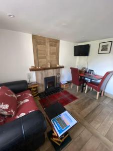 a living room with a couch and a fireplace at Mackenzie Cottage, Kinlochbervie in Oldshore