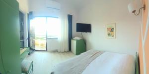a white bedroom with a bed and a window at Teras Motel 12 Adults Only in Foça