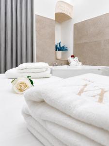 a white bedroom with two beds and a bath tub at Luxury Way Blue Essence in Molfetta