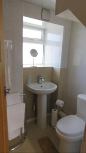 a bathroom with a sink and a toilet and a window at Mackenzie Cottage, Kinlochbervie in Oldshore +29 photos