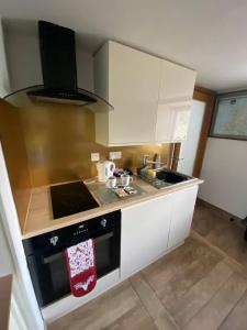 a kitchen with white cabinets and a stove top oven at Mackenzie Cottage, Kinlochbervie in Oldshore