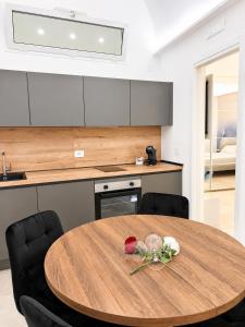 a kitchen with a wooden table with two chairs at Luxury Way Blue Essence in Molfetta +8 photos