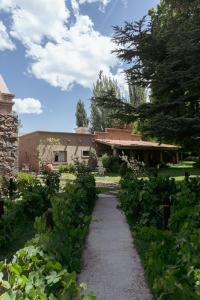 a pathway leading to a house with a building at Casa Entonada - Hotel Boutique in Chacras de Coria