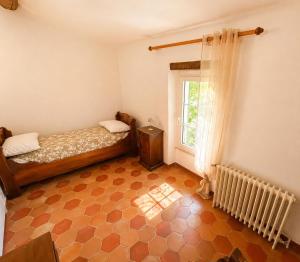 a small bedroom with a bed and a window at À minnanna in Banon
