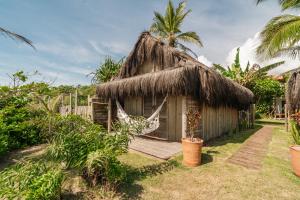 a small hut with a thatched roof at Vila Fruta Pão in Caraíva
