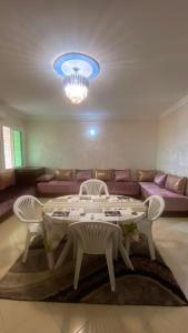 a living room with a table and chairs and a couch at Martil, Avenue Oum Kalthoum in Martil