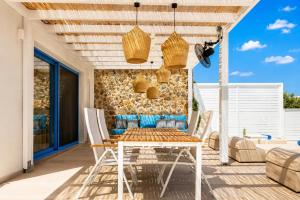 a patio with a table and chairs and a stone wall at Villa Castor in Gennadi