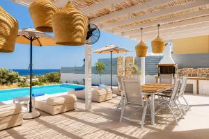 a patio with a table and chairs and a pool at Villa Castor in Gennadi