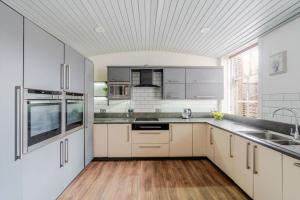 a kitchen with white cabinets and stainless steel appliances at Kirkland in Berwick-Upon-Tweed