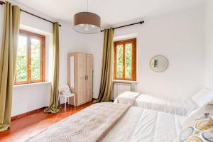 a bedroom with two beds and two windows at Fuga nel Parco Trebbia, vicino Grazzano/Bobbio in Rivergaro