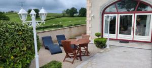 a patio with a table and chairs and a street light at La Tour D'Elaine in Essertenne