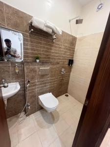 a bathroom with a toilet and a sink and a mirror at MorningInn in Prayagraj +4 photos