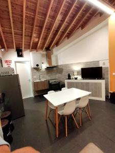 a kitchen with a white table and chairs in a room at Sons da Ribeira in Ribeira Grande