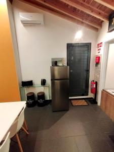 a kitchen with a stainless steel refrigerator in a room at Sons da Ribeira in Ribeira Grande