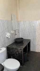 a bathroom with a white toilet and a sink at Villa Nacita in Bumbang