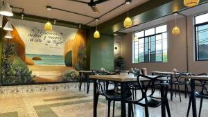 a restaurant with tables and chairs and a mural at Mandala Medellín Belén By GyC Hotels in Medellín