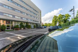 Blick von der Motorhaube eines Autos auf einem Parkplatz in der Unterkunft Hotel Capital in Rovigo