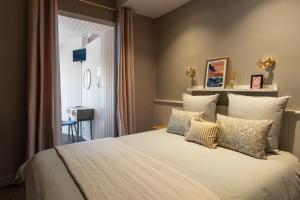 a bedroom with a large bed with pillows at La CHARMILLE PADIRAC in Padirac
