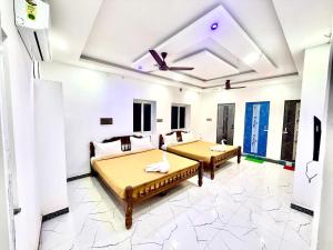 a room with two beds and a ceiling at natchiyar home stay in Rāmeswaram