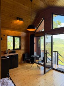 a kitchen and dining room in a cabin with windows at Mtskheta Chalet in Mtskheta