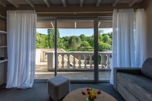 a living room with a couch and a view of a balcony at La CHARMILLE PADIRAC in Padirac