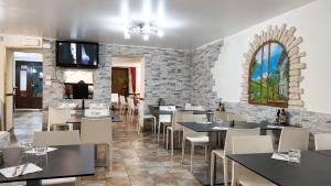 a restaurant with tables and chairs and a stone wall at Hotel Chalet d'Oulx in Oulx