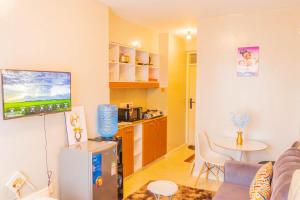 a living room with a refrigerator and a kitchen at HIDEOUT BnB with swimming pool in Kiambu