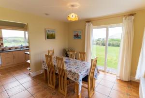 a kitchen and dining room with a table and chairs at Montbretia - Ballinskelligs in Dungeagan +14 photos