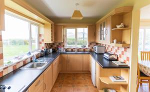 a kitchen with a sink and a window at Montbretia - Ballinskelligs in Dungeagan