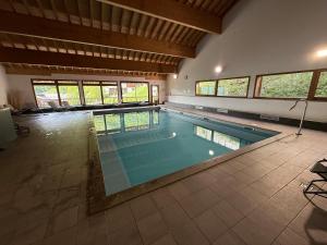 a large swimming pool in a large room with windows at Appartement 6 couchages - Orelle 3 Vallées - Spa & Piscine - in Orelle