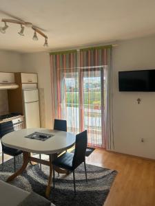 a living room with a table and chairs and a kitchen at Guest House Ana in Zadar