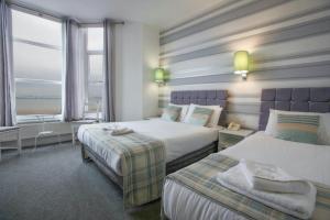 a hotel room with two beds and a window at Tiffany's Hotel in Blackpool +63 photos
