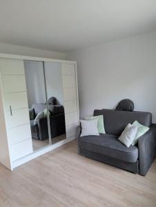 a living room with a couch and a large mirror at Apartament Las in Żagań +2 photos