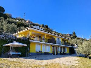 a yellow house on a hill with an umbrella at Le Drupe in Chiavari
