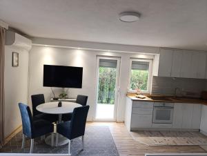 a kitchen with a table and chairs and a kitchen with a tv at VA vikendica Tesanj in Tešanj