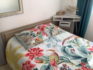 a bed with a blanket with a bird on it at Les clés du temps in Essarts