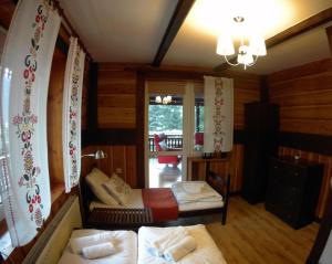 a bedroom with two beds in a room with wooden walls at Willa Rytro dom wakacyjny w górach do wynajęcia na wyłączność dla 15 osób in Rytro