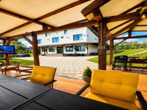 a patio with a table and two yellow chairs at Hillcrest Panorama Valea Prahovei in Poiana Comarnic