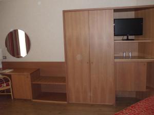una camera con un armadio in legno e una TV. di Nicotel Barletta a Barletta